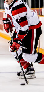 Image of a 67's player skating with the puck