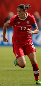 Image of woman playing soccer in a Canadian National team uniform