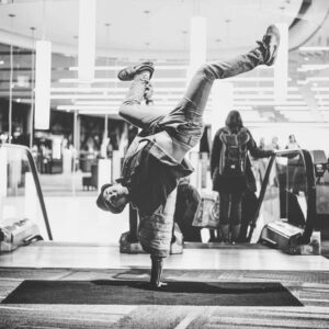 Image of breakdancer in a hand stand with his legs up in a pose