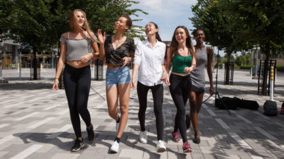 Five young women walking through Lansdowne, laughing and shopping.