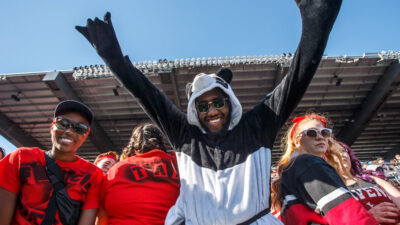 Image of Carleton Ravens fans cheering in Panda costume at the 2017 Panda Game