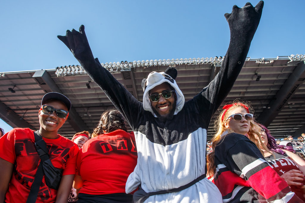 Image of Carleton Ravens fans cheering in Panda costume at the 2017 Panda Game