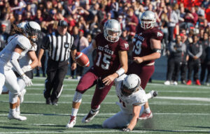 gee-gees player holding the ball and ravens' player falling