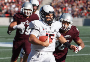 Ravens' player holding the ball and two gee-gees players running after him