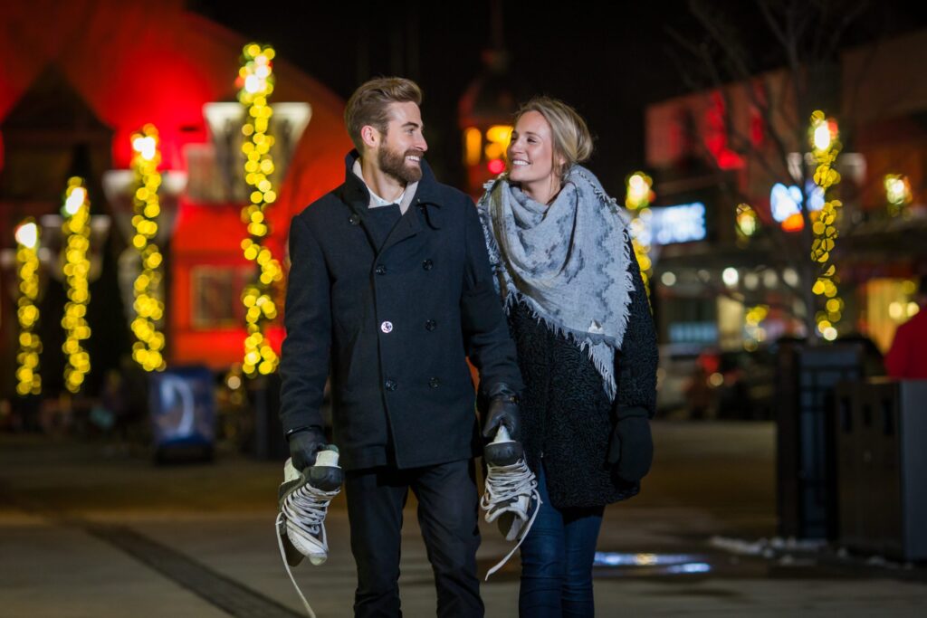 young couple walking through lansdowne at night with twinkly lights