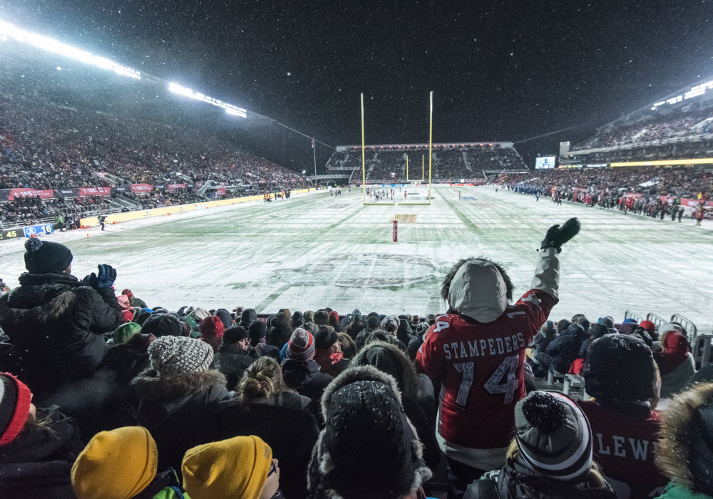 Full stadium of fans cheer for the 105th Grey Cup at TD Place on a snowy night
