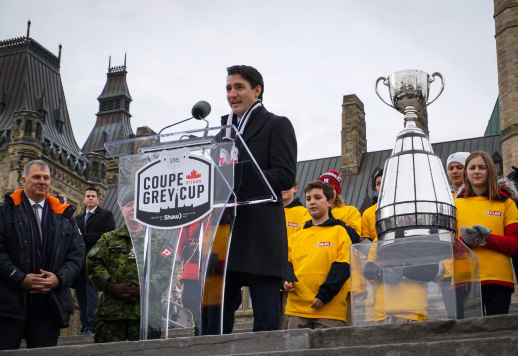 Image of Justin Trudeau speaking on stage at a Grey Cup ceremony at Parliament Hill