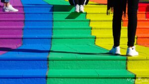 People standing on rainbow stairs