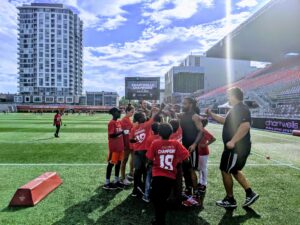 players and kids training on the field at TD Place