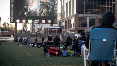 Image of people on the field at TD Place watching a movie on the big screen