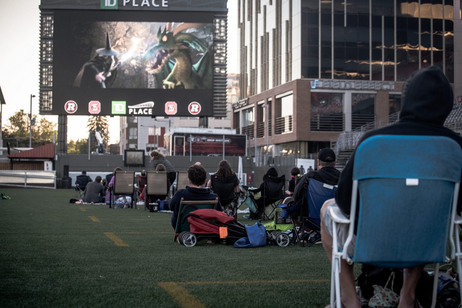 Image of people on the field at TD Place watching a movie on the big screen